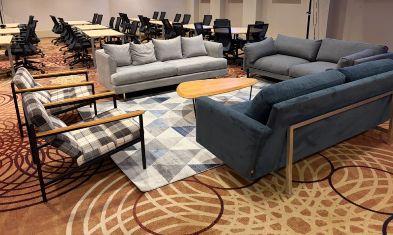Lounge seating with sofas, armchairs and coffee table in front of meeting room setup