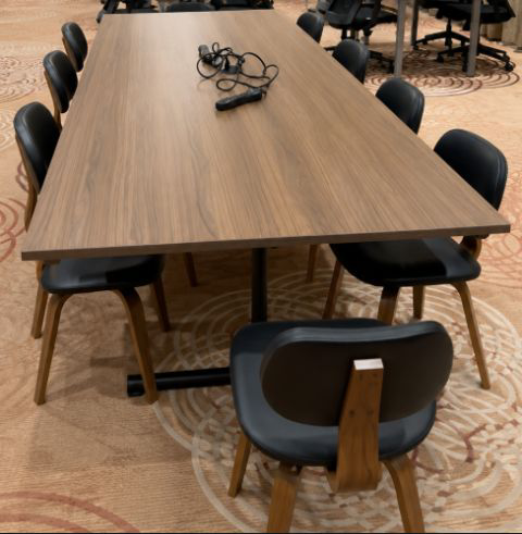 Wooden boardroom table with black leather chairs